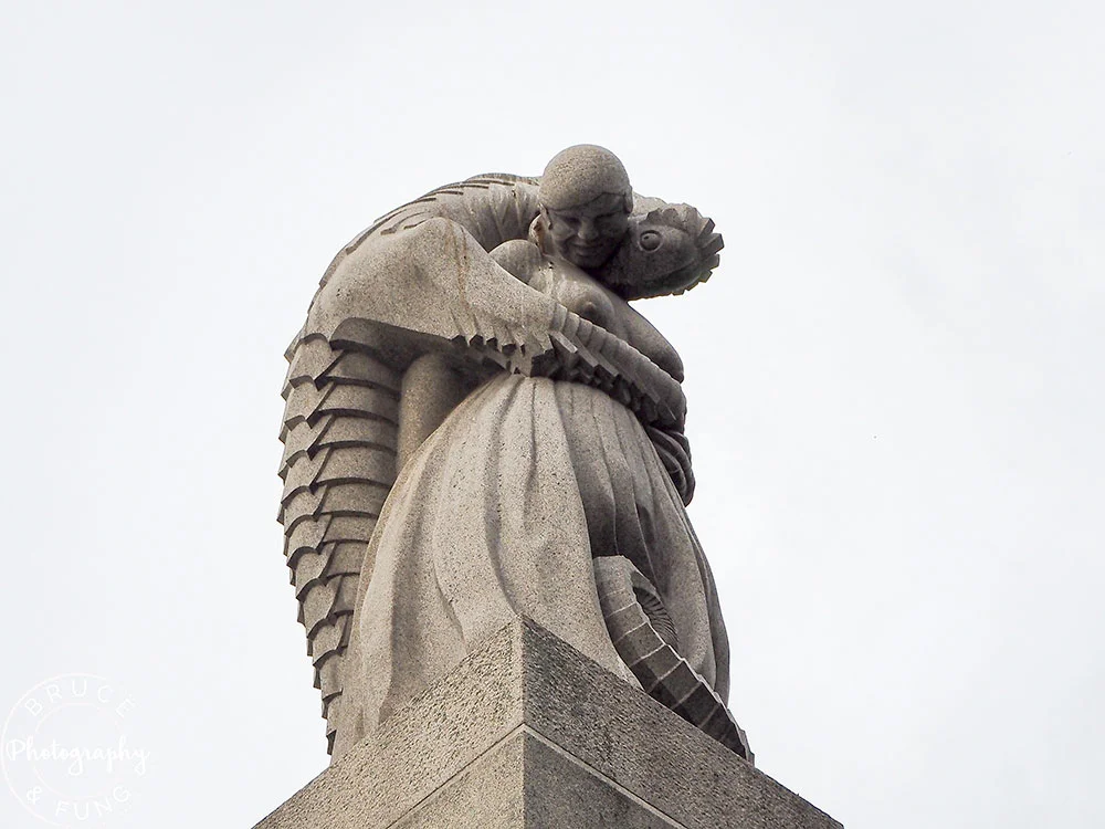 a woman canoodling with a lizard statue at Vigeland Sculpture Park